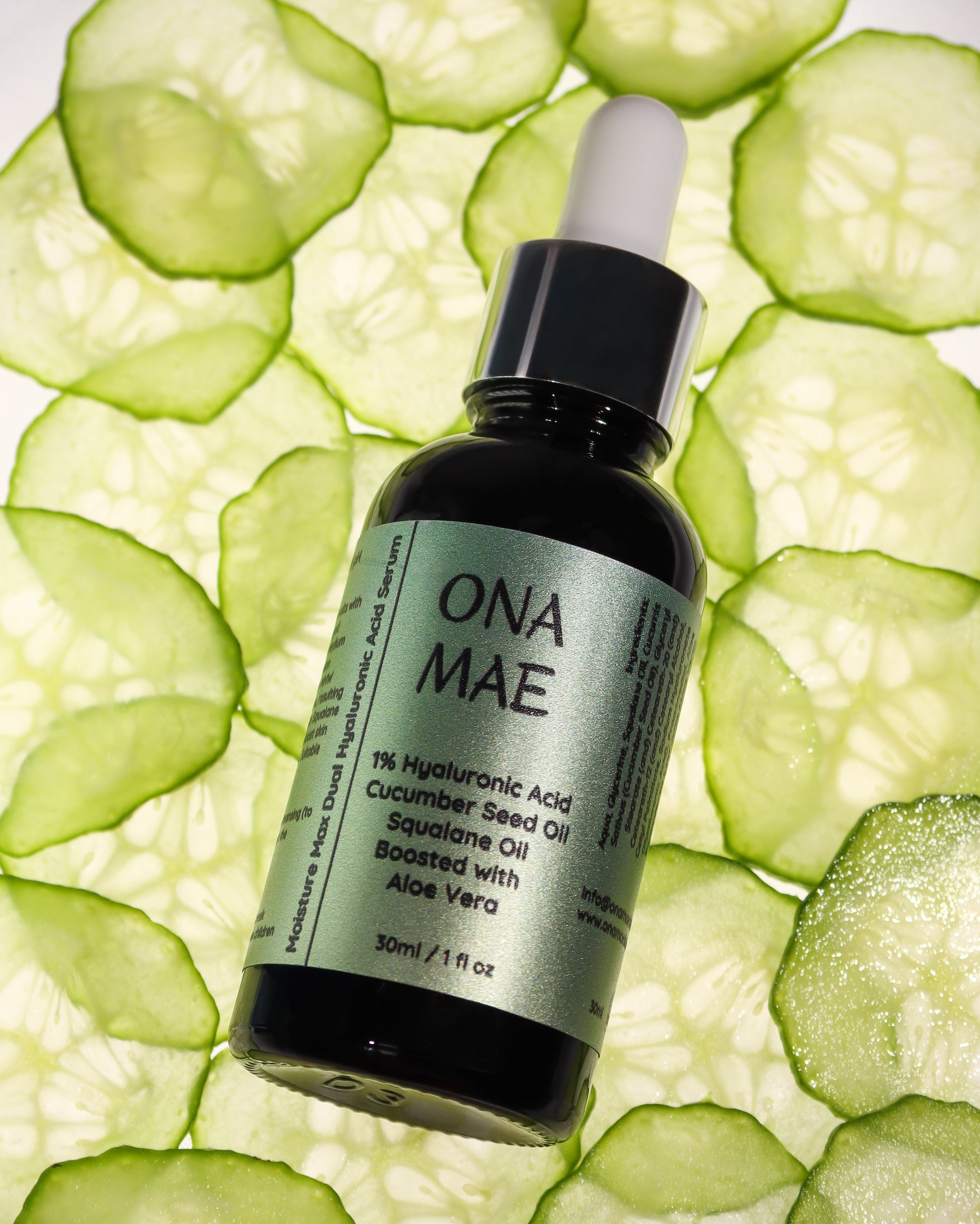 A 30ml dropper bottle of ONA MAE Cucumber Seed Oil Squalane Oil, set against a background of sliced cucumber rounds.